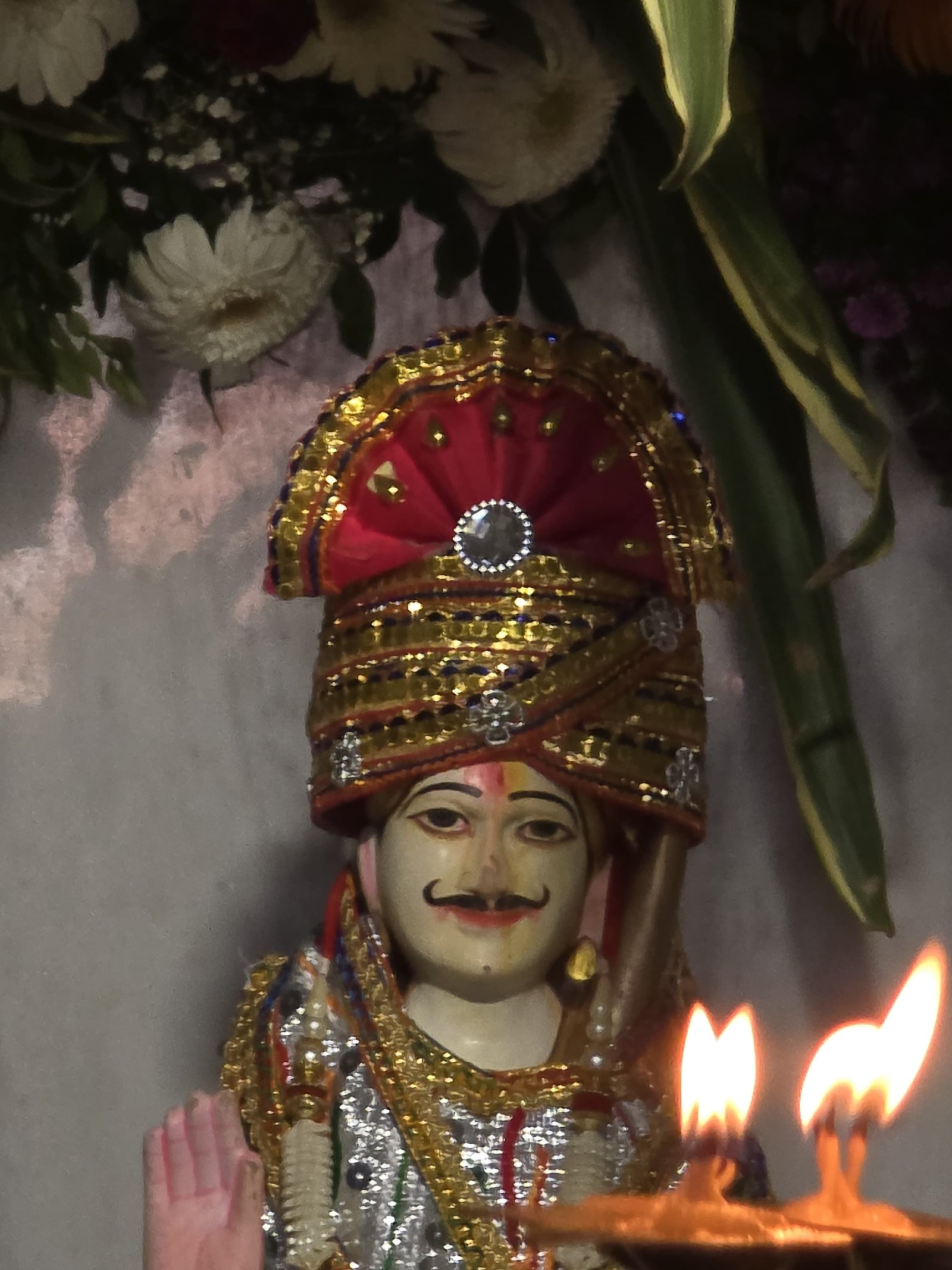 Decorated deity with aarti flame